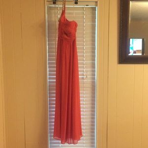 A coral one shoulder floor length prom dress